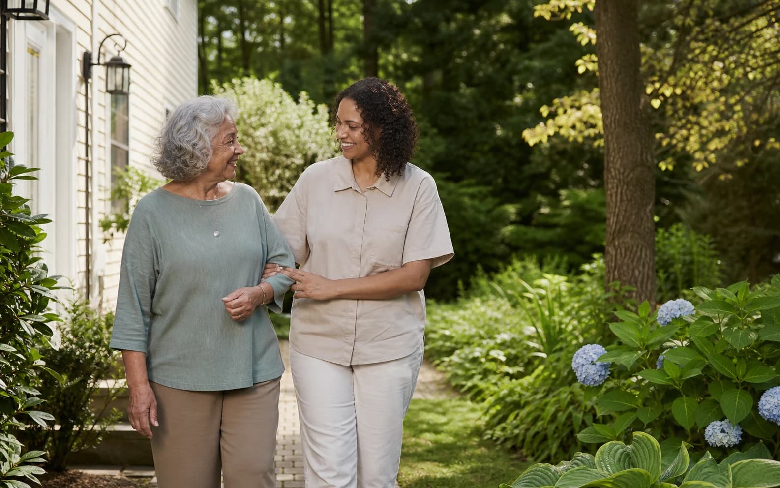 A senior caregiver walking with an older woman outside her home in Westchester County